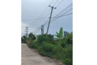 Tiang PLN miring di Perumahan Griya Assalam Alam Barajo Jambi belum diperbaiki meski warga sudah melapor sejak setahun lalu.( Poto : TribunJambi.com ).