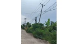 Tiang PLN miring di Perumahan Griya Assalam Alam Barajo Jambi belum diperbaiki meski warga sudah melapor sejak setahun lalu.( Poto : TribunJambi.com ).