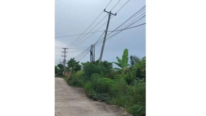 Tiang PLN miring di Perumahan Griya Assalam Alam Barajo Jambi belum diperbaiki meski warga sudah melapor sejak setahun lalu.( Poto : TribunJambi.com ).