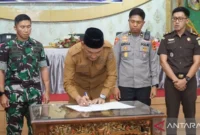 Bupati Sarolangun Hurmin saat menandatangani nota kesepakatan Pilkades serentak di wilayah tersebut, Senin (25/5/2026). ( Poto :ANTARA)