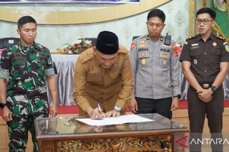 Bupati Sarolangun Hurmin saat menandatangani nota kesepakatan Pilkades serentak di wilayah tersebut, Senin (25/5/2026). ( Poto :ANTARA)