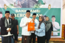 Dirut Bank Jambi menyerahkan daging kurban secara simbolis( Poto : jambione.com ).
