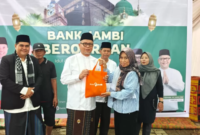 Dirut Bank Jambi menyerahkan daging kurban secara simbolis( Poto : jambione.com ).