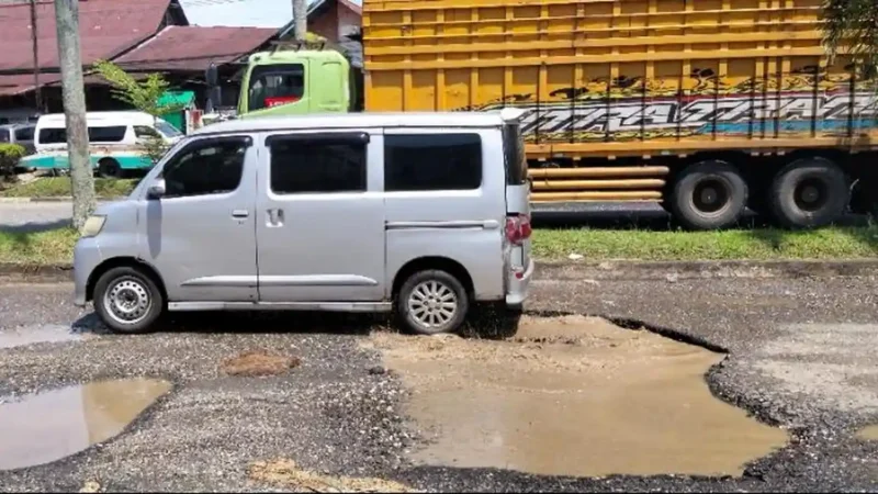 Jalan Jalur Tiga Bangko di Kabupaten Merangin rusak parah dengan banyak lubang yang sering menyebabkan kecelakaan.( Poto : Tribunjambi.com / Freanky Widarta ).