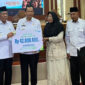 Pemkab Muaro Jambi menyerahkan santunan JKM BPJS Ketenagakerjaan kepada ahli waris Ketua RT Sekernan sebagai bentuk perlindungan sosial.( Poto : bpjstk/infojambi.com).