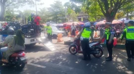 Petugas kepolisian lalu lintas melakukan pemeriksaan kendaraan dalam sebuah operasi di jalan raya.( Poto : pariwarajambi.com )