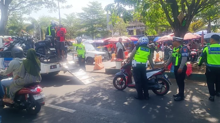 Petugas kepolisian lalu lintas melakukan pemeriksaan kendaraan dalam sebuah operasi di jalan raya.( Poto : pariwarajambi.com )