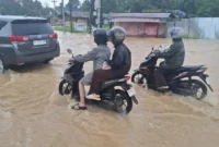 Banjir Simpang Empat Kenali merendam Kota Baru Jambi usai hujan deras sejak subuh, genangan lutut, lalu lintas tersendat dan warga terdampak.( poto : tribunjambi.com )