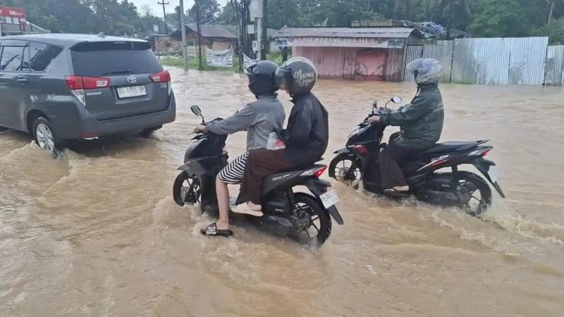 Banjir Simpang Empat Kenali merendam Kota Baru Jambi usai hujan deras sejak subuh, genangan lutut, lalu lintas tersendat dan warga terdampak.( poto : tribunjambi.com )