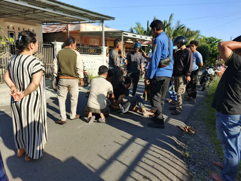 Petugas kepolisian bersama warga mengamankan pelaku pembacokan di Tungkal Ilir, Kabupaten Tanjung Jabung Barar.( poto : metrojambi.com )