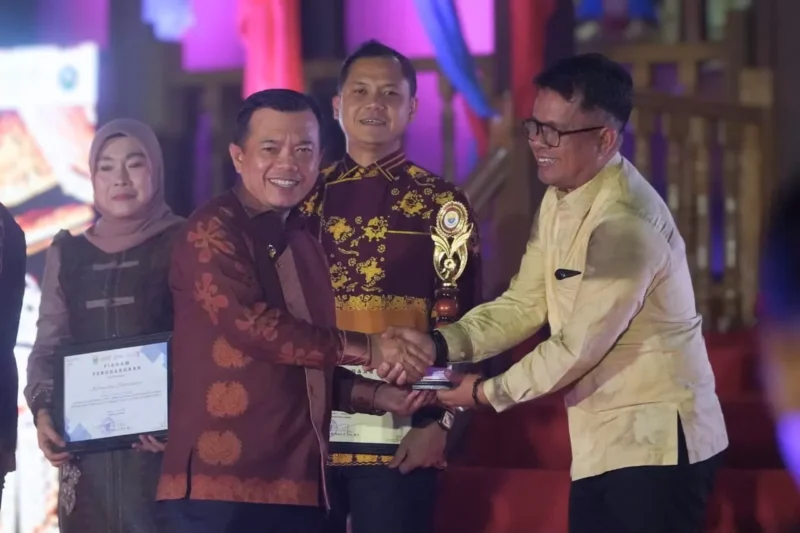 Gubernur Jambi, Al Haris, secara langsung menyerahkan penghargaan Terbaik II kepada Wakil Bupati Tebo, Nazar Efendi, pada Jumat (26/6/2026).(  poto : jambione.com )
