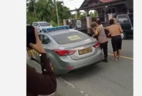 Seorang pria di Kerinci dimasukkan ke mobil sedang patroli polisi, Rabu (10/6/2026). Peristiwa itu terjadi di Kecamatan Tanah Kampung, Kota Sunfgai Penuh, saat siang hari.( poto : tribunjambi.com )