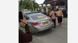 Seorang pria di Kerinci dimasukkan ke mobil sedang patroli polisi, Rabu (10/6/2026). Peristiwa itu terjadi di Kecamatan Tanah Kampung, Kota Sunfgai Penuh, saat siang hari.( poto : tribunjambi.com )