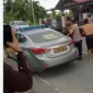 Seorang pria di Kerinci dimasukkan ke mobil sedang patroli polisi, Rabu (10/6/2026). Peristiwa itu terjadi di Kecamatan Tanah Kampung, Kota Sunfgai Penuh, saat siang hari.( poto : tribunjambi.com )