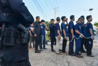 Warga binaan pemasyarakatan berjalan menuju bus dengan pengawalan petugas kepolisian saat pemindahan dari Lapas Kelas II A Jambi ke Sengeti, Kota Jambi, Jambi, Sabtu (6/6/2026).( poto : istimewa ).