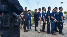 Warga binaan pemasyarakatan berjalan menuju bus dengan pengawalan petugas kepolisian saat pemindahan dari Lapas Kelas II A Jambi ke Sengeti, Kota Jambi, Jambi, Sabtu (6/6/2026).( poto : istimewa ).
