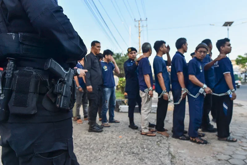 Warga binaan pemasyarakatan berjalan menuju bus dengan pengawalan petugas kepolisian saat pemindahan dari Lapas Kelas II A Jambi ke Sengeti, Kota Jambi, Jambi, Sabtu (6/6/2026).( poto : istimewa ).