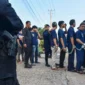 Warga binaan pemasyarakatan berjalan menuju bus dengan pengawalan petugas kepolisian saat pemindahan dari Lapas Kelas II A Jambi ke Sengeti, Kota Jambi, Jambi, Sabtu (6/6/2026).( poto : istimewa ).