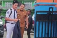 Bupati Merangin H. M. Syukur mengantar putranya, Shafiq, pada hari pertama masuk sekolah di SMP Negeri 1 Merangin, Senin (13/7/2026).(poto: jambiprima.com).