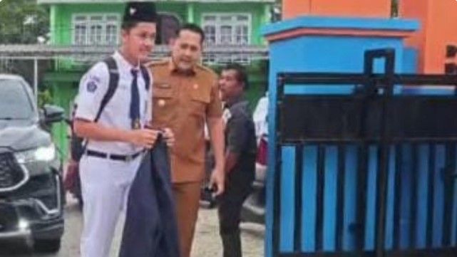 Bupati Merangin H. M. Syukur mengantar putranya, Shafiq, pada hari pertama masuk sekolah di SMP Negeri 1 Merangin, Senin (13/7/2026).(poto: jambiprima.com).