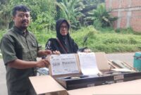 Ketua RT 12 Robin Robiansyah (kiri) menyerahkan kompor gratis kepada warga (kanan) di Jambi, Senin (13/7/2026).(poto: ANTARA).