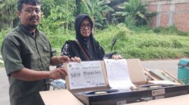Ketua RT 12 Robin Robiansyah (kiri) menyerahkan kompor gratis kepada warga (kanan) di Jambi, Senin (13/7/2026).(poto: ANTARA).