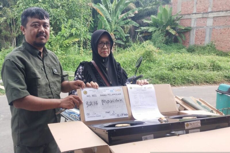 Ketua RT 12 Robin Robiansyah (kiri) menyerahkan kompor gratis kepada warga (kanan) di Jambi, Senin (13/7/2026).(poto: ANTARA).