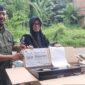 Ketua RT 12 Robin Robiansyah (kiri) menyerahkan kompor gratis kepada warga (kanan) di Jambi, Senin (13/7/2026).(poto: ANTARA).