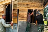 Satgas TMMD Ke-129 Kodim 0416/Bute memasang jendela rumah RTLH milik Maskur Hanapi di Desa Tanjung Agung, Kabupaten Bungo.(poto: jambiprima.com).