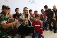 Wali Kota Sungai Penuh Alfin, S.H., menyapa salah seorang anak peserta sunatan massal Minker-JS ke-XIII saat meninjau pelaksanaan bakti sosial di RSUD H. Bakri Kota Sungai Penuh.( poto : jambiprima.com )