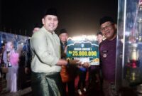 Bupati Merangin M. Syukur menyerahkan piala dan hadiah kepada Kafilah Kecamatan Sungai Manau yang keluar sebagai Juara Umum MTQH ke-52 Tingkat Kabupaten Merangin Tahun 2026.(poto: jambiprima.com).