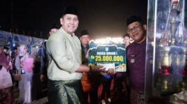 Bupati Merangin M. Syukur menyerahkan piala dan hadiah kepada Kafilah Kecamatan Sungai Manau yang keluar sebagai Juara Umum MTQH ke-52 Tingkat Kabupaten Merangin Tahun 2026.(poto: jambiprima.com).
