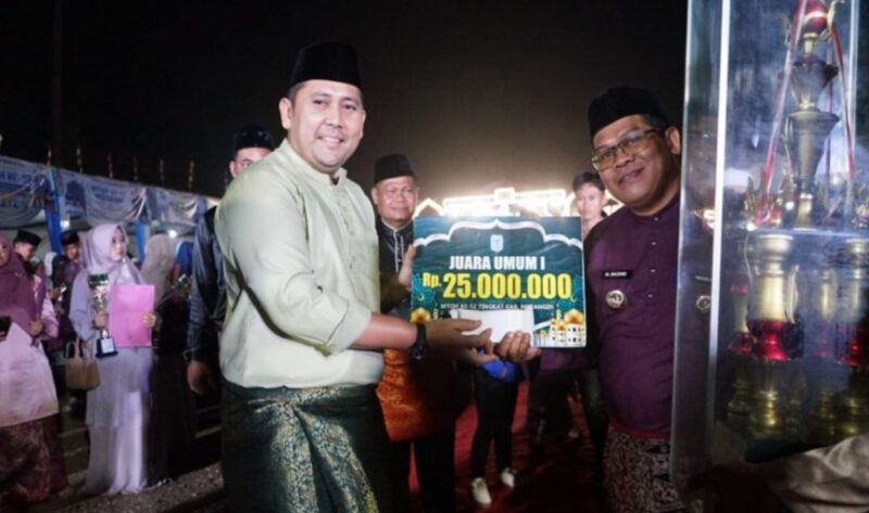 Bupati Merangin M. Syukur menyerahkan piala dan hadiah kepada Kafilah Kecamatan Sungai Manau yang keluar sebagai Juara Umum MTQH ke-52 Tingkat Kabupaten Merangin Tahun 2026.(poto: jambiprima.com).