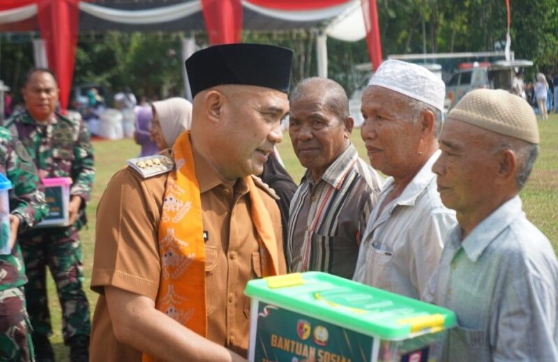 Bupati Bungo menyerahkan paket sembako kepada warga kurang mampu usai pembukaan TMMD Ke-129 di Desa Tanjung Agung. (poto: jambiprima.com).