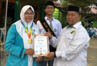 Suryadi, S.Ag., Wakil Kepala MAN 1 Bungo Bidang Humas dan TIK, menyerahkan piagam penghargaan kepada Nurhafizah Nadya atas prestasinya meraih Medali Emas bidang Matematika tingkat SMA dalam program SENADA, Senin (10/8/2026).(poto: jambiprima.com).