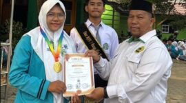 Suryadi, S.Ag., Wakil Kepala MAN 1 Bungo Bidang Humas dan TIK, menyerahkan piagam penghargaan kepada Nurhafizah Nadya atas prestasinya meraih Medali Emas bidang Matematika tingkat SMA dalam program SENADA, Senin (10/8/2026).(poto: jambiprima.com).