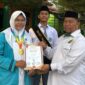 Suryadi, S.Ag., Wakil Kepala MAN 1 Bungo Bidang Humas dan TIK, menyerahkan piagam penghargaan kepada Nurhafizah Nadya atas prestasinya meraih Medali Emas bidang Matematika tingkat SMA dalam program SENADA, Senin (10/8/2026).(poto: jambiprima.com).