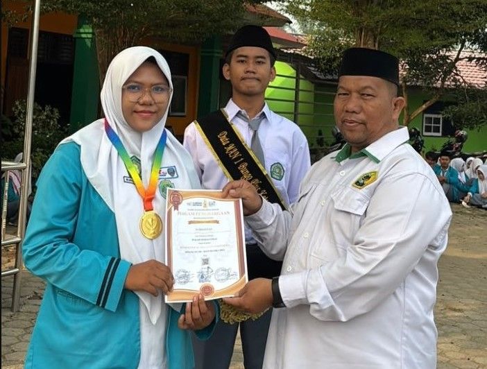 Suryadi, S.Ag., Wakil Kepala MAN 1 Bungo Bidang Humas dan TIK, menyerahkan piagam penghargaan kepada Nurhafizah Nadya atas prestasinya meraih Medali Emas bidang Matematika tingkat SMA dalam program SENADA, Senin (10/8/2026).(poto: jambiprima.com).