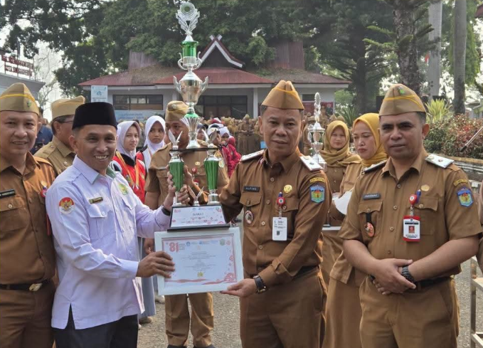 Sekda Alpian menyerahkan piala penghargaan Lomba Barisan Indah kepada Kepala Sekolah MTsn 1 Sungai Penuh,Bapak Soni Indra.(poto: istimewa).