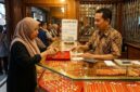 Ilustrasi Warga memilih perhiasan emas di etalase toko kawasan Jambi, memantau pergerakan harga terbaru untuk investasi.(poto: AI).
