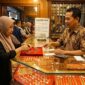 Ilustrasi Warga memilih perhiasan emas di etalase toko kawasan Jambi, memantau pergerakan harga terbaru untuk investasi.(poto: AI).