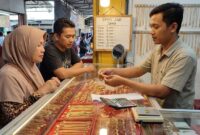 Ilustrasi Pedagang melayani warga yang memilih perhiasan emas di salah satu toko emas kawasan pasar Kota Jambi.(poto: AI).