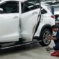 Mekanik memasang footstep elektrik pada bodi mobil Toyota Innova Zenix untuk memudahkan akses keluar-masuk penumpang.(poto: AI).