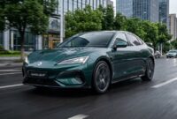 Ilustrasi Mobil listrik Danza Z9 GT melaju kencang di jalan perkotaan, menampilkan desain bodi sporty dan modern berwarna hijau.(poto: AI).
