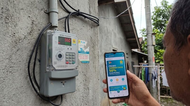 Warga mengecek promo tambah daya 50 persen di PLN Mobile dekat meteran listrik rumah.(ilustrasi poto: AI).