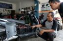 Ilustrasi Mekanik memeriksa rangkaian baterai SLA pada kompartemen motor listrik di sebuah bengkel servis kendaraan listrik.(poto: AI).