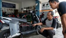 Ilustrasi Mekanik memeriksa rangkaian baterai SLA pada kompartemen motor listrik di sebuah bengkel servis kendaraan listrik.(poto: AI).