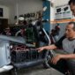 Ilustrasi Mekanik memeriksa rangkaian baterai SLA pada kompartemen motor listrik di sebuah bengkel servis kendaraan listrik.(poto: AI).