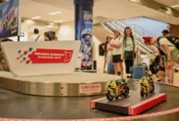 Pengelola Bandara Internasional Lombok menyulap area terminal kedatangan dengan dekorasi lintasan sirkuit jelang perhelatan MotoGP Mandalika Lombok 2026.(poto: tvonenews.com).