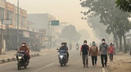 Ilustrasi Warga dan pengendara di Jambi terpaksa bermasker di tengah kepungan kabut asap pekat akibat karhutla.(poto: AI).